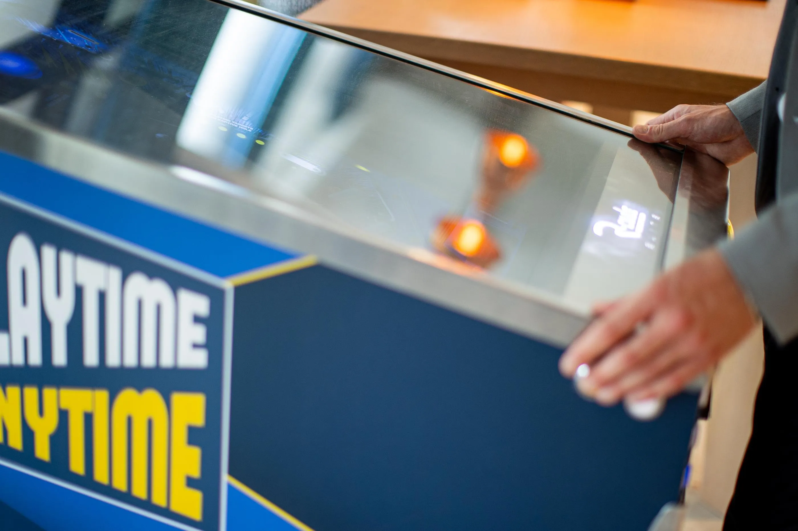 Une personne utilise un distributeur automatique avec l'inscription "ANYTIME"