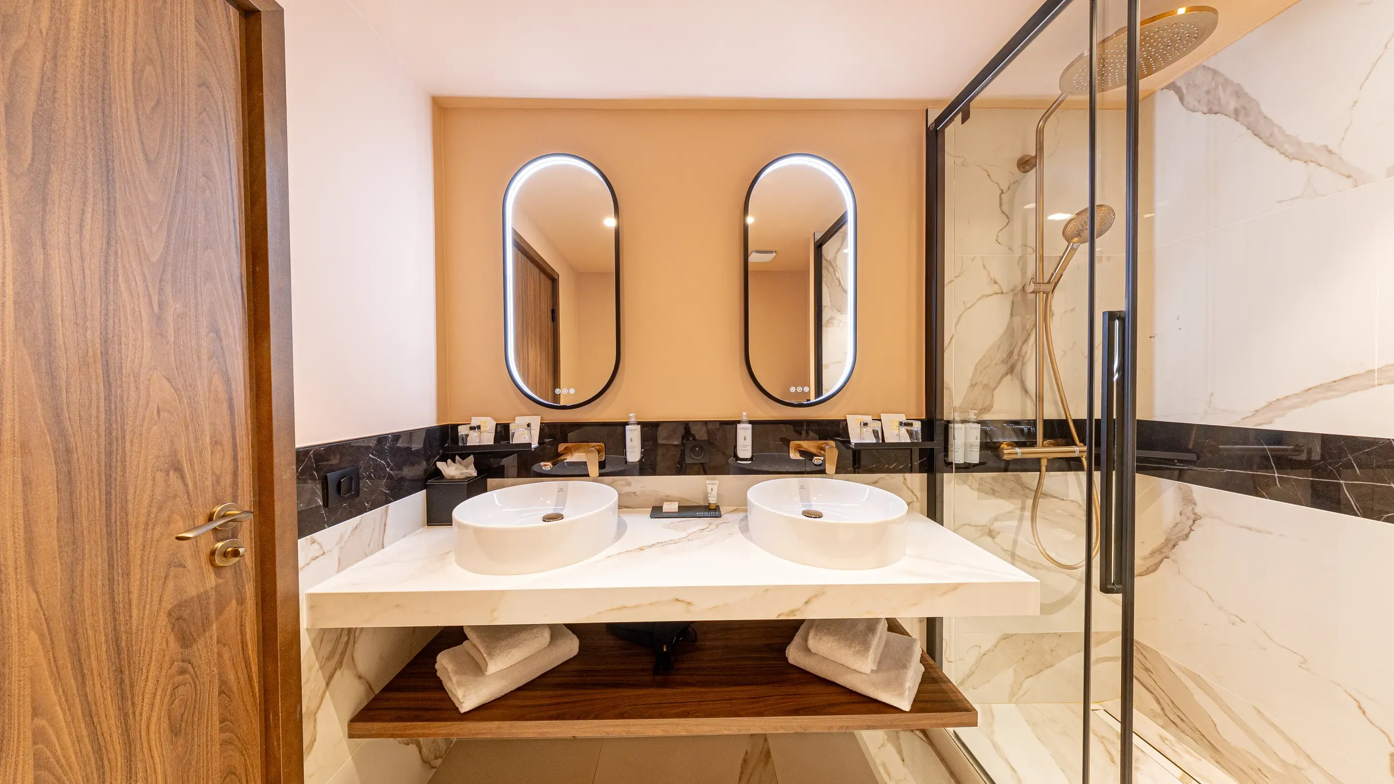 Salle de bain moderne avec double vasque, miroir ovale et douche en verre