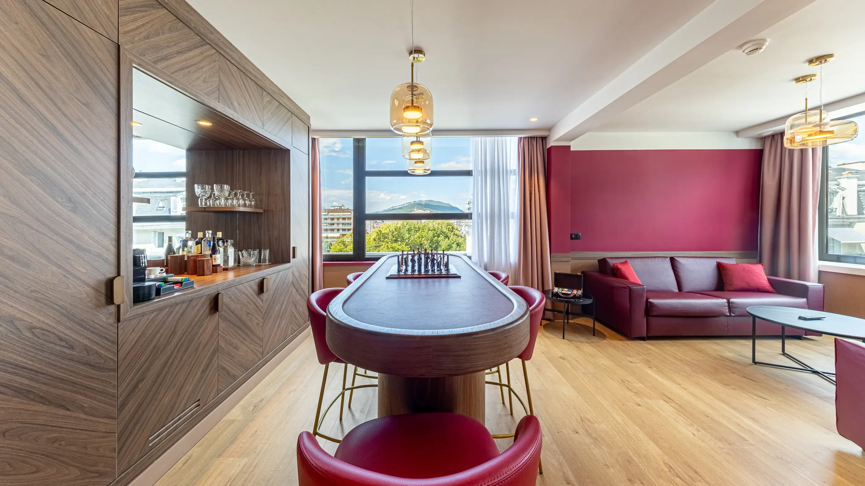 Salon avec table de poker, canapé, bar et vue sur la ville par une grande fenêtre